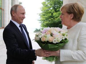 Russian President Vladimir Putin (L) welcomes German Chancellor Angela Merkel during their meeting in Sochi on May 18, 2018. (Mikhail KLIMENTYEV / SPUTNIK / AFP)