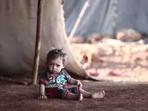 A child sits in front of a tent at a camp for the displaced from the rebel-held Syrian province of Idlib, at the village of al-Ghadfa, southeast of the province on September 2, 2018. (Nazeer AL-KHATIB / AFP)