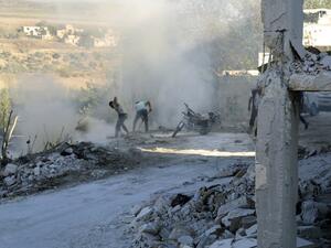 Syrians use dirt to put out a fire at the scene of a reported air strike in the district of Jisr al-Shughur, in the Idlib province, on September 4, 2018. (Zein Al RIFAI / AFP)