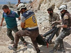 Members of the Syrian Civil Defense, also known as the 'White Helmets,' carrying a victim after airstrikes in Kafr Ain in the Idlib province, September 7, 2018. (AFP/Anas al-Dyab)