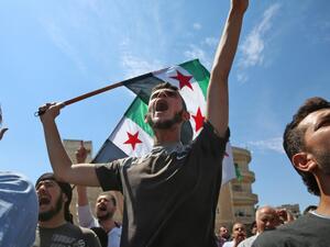 Syrian protesters wave the flag of the opposition as they demonstrate against the regime and its ally Russia, in the rebel-held city of Idlib on September 7, 2018 (ZEIN AL RIFAI/AFP)