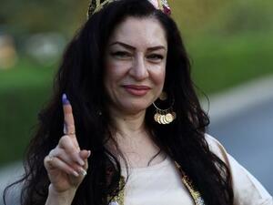 An Iraqi Kurdish woman shows her ink-stained index finger after casting her ballot for the parliamentary election at a polling station in Arbil, the capital of the Kurdish autonomous region in northern Iraq, on September 30, 2018. 
SAFIN HAMED / AFP