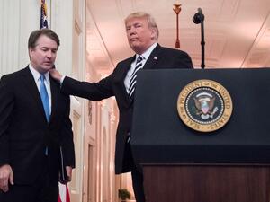 US President Donald Trump (R) pats Associate Justice of the US Supreme Court Brett Kavanaugh (L)  (AFP)