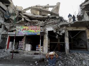 Labourers clear debris from a destroyed building in the Syrian city of Raqa (AFP)
