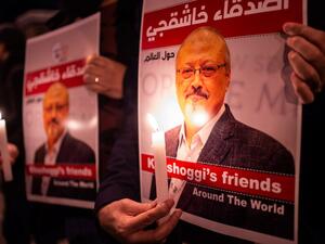 People hold posters picturing Saudi journalist Jamal Khashoggi and lightened candles during a gathering outside the Saudi Arabia consulate in Istanbul, on October 25, 2018. (Yasin AKGUL / AFP)