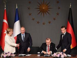 Russian President Vladimir Putin (2ndL) and German Chancellor Angela Merkel (L) shake hands after a conference with Turkish President Recep Tayyip Erdogan (2ndR) and French President Emmanuel Macron (R) during a summit OZAN KOSE / AFP