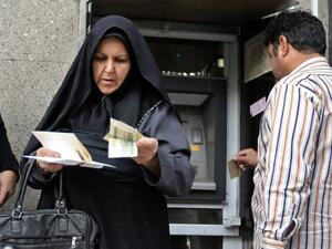 People withraw money from an automated teller machine in the Iranian capital Tehran's grand bazar on November 3, 2018 (AFP)