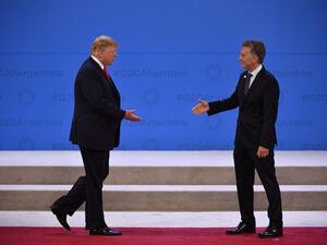 US President Donald Trump (L) is welcomed by Argentina's President Mauricio Macri at Costa Salguero in Buenos Aires during the G20 Leaders' Summit (AFP)