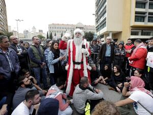 A Lebanese demonstrator, dressed as Santa Clause, delivers a speech during a demonstration against the country's political and economic situation on December 16, 2018, in the capital Beirut. (AFP)
