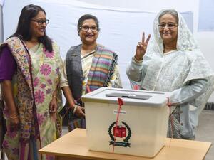 Bangladeshi Prime Minister Sheikh Hasina (R) flashes the victory symbol after casting her vote, as her daughter Saima Wazed Hossain (1st L) and her sister Sheikh Rehana (2nd L). (AFP)
