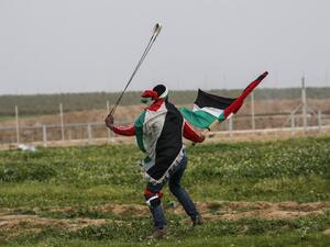 A Palestinian protester uses a slingshot during clashes with Israeli forces. (AFP/ File Photo)