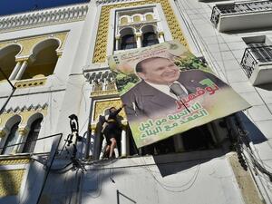 Algerian demonstrators tear down a large billboard with a picture of their current President Abdelaziz Bouteflika on February 22, 2019 in Algiers.(AFP)