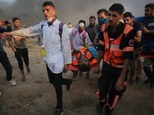 Palestinian paramedics carry a wounded protester during clashes with Israeli forces east of Gaza city, along the Gaza-Israel border in the Gaza Strip. (AFP/File)