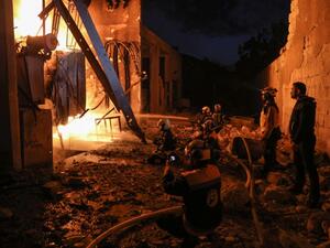 Members of the Syrian Civil Defence (The White Helmets) put out a fire at the site of reported air strikes inside the jihadist-held city of Idlib, on March 13, 2019. (AFP/ File)