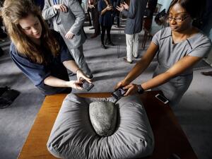 Members of the press take pictures of a Babylonian cuneiform kudurru (boundary stone) which was looted from Iraq on March 19, 2019 at the British museum in London (AFP)