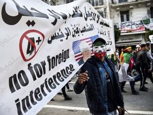 An Algerian wearing a Guy Fawkes' mask defaced with the national colours marches during a demonstration against ailing President Abdelaziz Bouteflika in the capital Algiers on March 22, 2019. (AFP/ File)