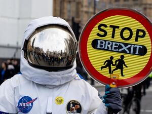 A person dressed as an astronaught holding a school traffic crossing sign reading "Stop Brexit" joins a march and rally organised by the pro-European People's Vote campaign for a second EU referendum in central London (AFP)