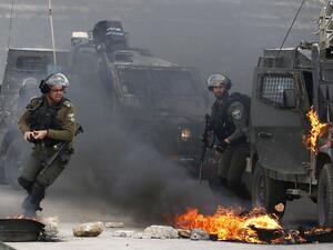 Israeli border guards move away from a burning military vehicle during clashes with Palestinian demonstrators who took to the streets on the outskirts of Ramallah in West Bank. (AFP/ File)
