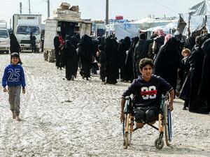 Veiled women, living in al-Hol camp which houses relatives of Islamic State (IS) group members, stand in queue to receive goods in the camp in al-Hasakeh governorate in northeastern Syria on March 28, 2019. 
GIUSEPPE CACACE / AFP 