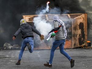 A Palestinian man throws back a tear gas canister during clashes with Israeli forces following a demonstration marking "Land Day" in the occupied West Bank on March 30, 2019. (AFP/ File photo)