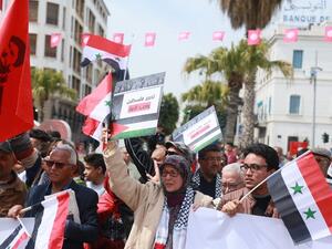 Tunisians hold the Syrian and Palestinian flags as they demonstrate against the Arab League Summit and the United States’ recognition of Israeli sovereignty over the Golan Heights. (AFP)