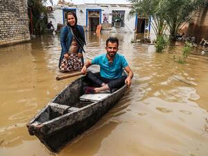 An Iranian man sits in a boat at his flooded garden in a village around the city of Ahvaz, in Iran's Khuzestan province (AFP)