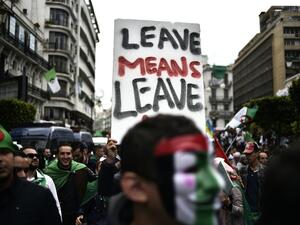 Algerians hold a placard as they take part in an anti-government demonstration, on April 5, 2019 in the capital Algiers. (RYAD KRAMDI / AFP)