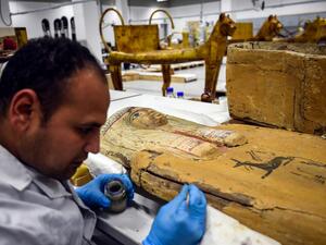 A restorer works on a sarcophagus part of the Tutankhamun collection at the restoration lab of the newly-built Grand Egyptian Museum (GEM) in Giza on the southwestern outskirts of the capital Cairo on April 7, 2019. 
(Mohamed el-Shahed / AFP)