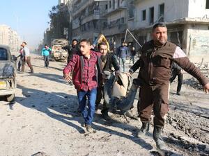 Syrians carry the body of a victim following a reported Syrian regime air strike in a rebel-controlled area in the northern city of Aleppo, on February 8, 2016. (AFP/Ameer al-Halbi)