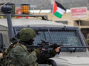 This file photo taken on February 6, 2016 shows an Israeli soldier aiming fire during clashes with Palestinian youths in the village of Qabatiyah, near the West Bank town of Jenin. (AFP/Jaafar Ashtiyeh)