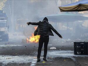A protester stands close to a fire, during clashes between Turkish forces and Kurdish people in the center of Diyarbakir, during a protest against a curfew in the Sur district of Diyarbakir, on March 2, 2016. (AFP/Ilyas Askengin)