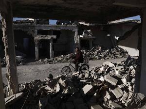 A Syrian man rides his bicycle past the rubble of destroyed buildings on March 7, 2016, in the rebel-held town of Douma, on the outskirts of the capital Damascus. (AFP/Sameer Al-Doumy)