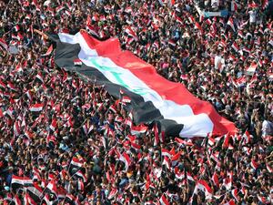 Supporters of Iraqi Shia cleric Moqtada al-Sadr wave national flags during a demonstration calling for governmental reform and elimination of corruption on March 11, 2016, in Baghdad's Tahrir Square. (AFP/Ahmad al-Rubaye)