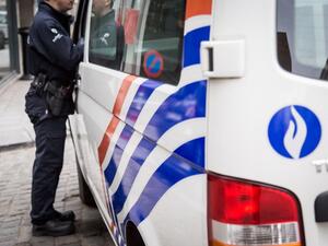 A Belgian police officer stands next to police car outside the Belgian Federal Police headquarters in Brussels on March 19, 2016. (AFP/Aurore Belot)