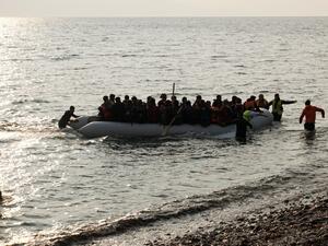 Refugees and migrants on a rubber boat arrive at the Greek island of Lesbos early on March 20, 2016. (AFP/STR)