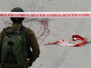 Blood stains from the body of a Palestinian assailant who was allegedly shot in the head by an Israeli soldier as he lay wounded on the ground after injuring an Israeli soldier with a fellow Palestinian attacker in a stabbing assault, stain the ground on March 24, 2016. (AFP/Hazem Bader)