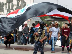 Iraqi security forces stand guard during a protest by supporters of Iraqi Shiite cleric Moqtada al-Sadr calling for governmental reform and elimination of corruption on March 25, 2016, outside the main gates of Baghdad's Green Zone. (AFP/Ahmad al-Rubaye)