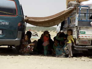 Syrian families, who fled the fighting between Syrian Arab Coalition fighters and Daesh in the town of Manbij, rest under a blanket at an encampment on the outskirts of the town, 20km away from the center, on June 4, 2016. (AFP/Delil Souleiman)