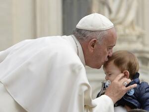 Pope Francis kisses a baby as he arrives for his weekly general audience at St Peter's square on September 30, 2015 at the Vatican. (AFP/Andreas Solaro)