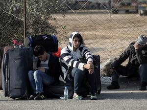 Palestinians await permission to enter Egypt at the Rafah border crossing in southern Gaza (AFP/File Photo)	