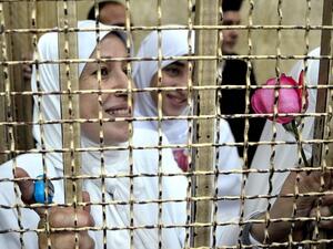 Women prisoners look out a barred window of Al-Qanater prison in Cairo (AFP/File Photo)

