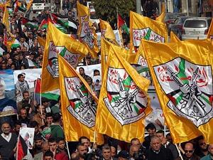 Palestinian demonstrators hold Fatah party flags as they demonstrate in the center of the West Bank city of Hebron. (AFP/HAZEM BADER)
