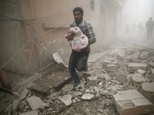 Man carries a baby in bomb-shelled Douma, Syria, AFP/File