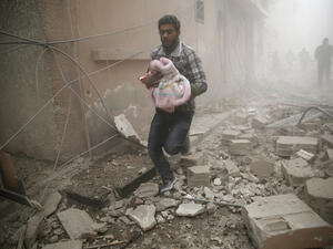 Man carries a baby in bomb-shelled Douma, Syria, AFP/File