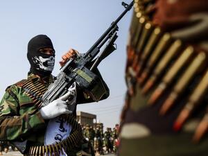 A picture taken on September 16, 2017 shows masked members of the Imam Ali Division, one of the groups fighting within the Hashed al-Shaabi (Popular Mobilisation) paramilitaries, marching with machine guns in a military parade in the holy shrine city of Najaf in central Iraq. 
(Haidar HAMDANI / AFP)