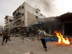 Civilians and members of the Syrian Civil Defence, known as the White Helmets, run at the scene of a reported air strike on the city of Maaret al-Numan in Syria's rebel-held Idlib province on Jan. 3, 2018 (OMAR HAJ KADOUR/AFP)