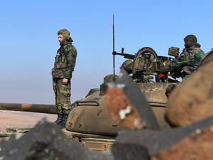 Members of the Syrian government forces stand on a tank in Jabal al-Hass in the southern part of Aleppo province as they advance towards the Abu Duhur military airport in the ongoing offensive against opposition fighters on January 14, 2018. Russia-backed regime troops are aiming to reach the Abu Duhur base as part of a weeks-long assault against Hayat Tahrir al-Sham (HTS), which is dominated by Al-Qaeda's former Syria affiliate. 
