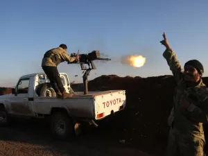 Turkish-backed fighters from the Free Syrian Army stand in the Tal Malid area, north of Aleppo, as they fire towards Kurdish People's Protection Units (YPG) positions in the village of Um al-Hosh, in the area of Afrin, on Jan. 20, 2018 (Nazeer al-Khatib / AFP)