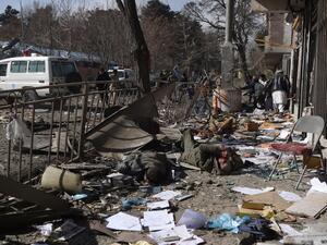 Afghan volunteers carry bodies at the scene of a car bomb exploded in front of the old Ministry of Interior building in Kabul on Jan. 27, 2018 (WAKIL KOHSAR / AFP)