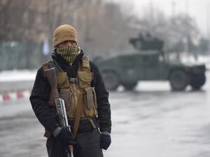 A member of an Afghan security detail guards the site of an ongoing attack near the Marshal Fahim Military Academy base in Kabul on Jan. 29, 2018 (WAKIL KOHSAR / AFP)